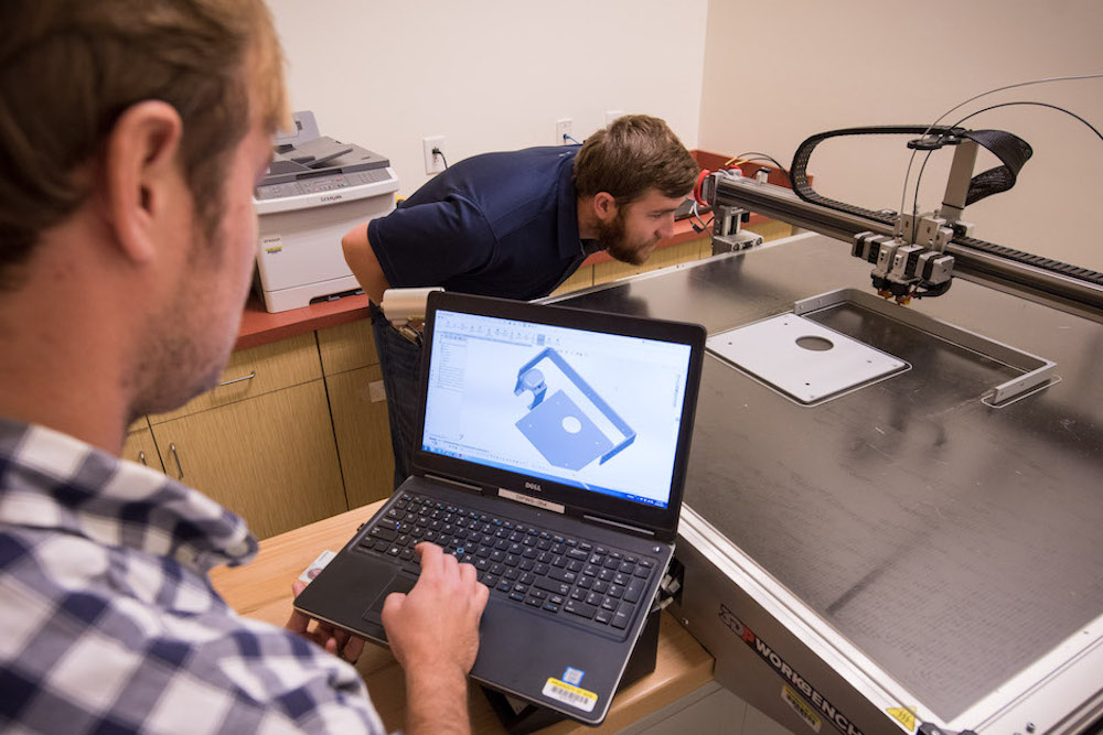 美国南卡罗来纳州查尔斯顿(2017年10月24日)SPAWAR系统中心(SSC)大西洋区员工Josh Heller(左)正在检查用于增层制造的CAD软件设计，而Ryan Wilhite正在验证打印机是否正确校准。通过使用增材制造技术(又称3D打印)，SSC大西洋公司的工程师和科学家可以为新部件和替换部件设计和创建原型，并增强和修改现有产品。SSC大西洋公司开发、获得并提供指挥、控制、通信、计算机、情报、监视和侦察(C4ISR)系统、信息技术和空间能力的生命周期支持。作为美国海军最先进的工程中心，SSC Atlantic负责设计、制造、测试、现场和支持许多目前和未来正在使用的最先进的C4ISR系统。(美国海军图片，乔·布林格/发布)
